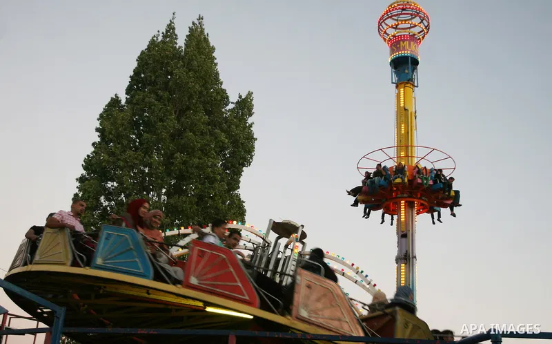 Palestinians enjoy the second day of Eid al-Fitr in an amusement park, in the West Bank city of Ramallah, Monday, Aug. 20, 2012. Eid, one of the most important holidays in the Muslim world, is marked with prayers, family...