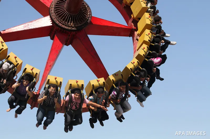 Palestinians enjoy a ride in an amusement park on the third day of Eid al-Fitr, marking the end of Islam's fasting holy month of Ramadan, in Gaza City on August 21, 2012. Photo by Majdi Fathi