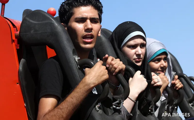 Palestinians enjoy a ride in an amusement park on the third day of Eid al-Fitr, marking the end of Islam's fasting holy month of Ramadan, in Gaza City on August 21, 2012. Photo by Majdi Fathi