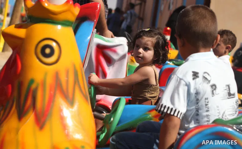 Palestinians enjoy a ride in an amusement park on the third day of Eid al-Fitr, marking the end of Islam's fasting holy month of Ramadan, in Gaza City on August 21, 2012. Photo by Majdi Fathi