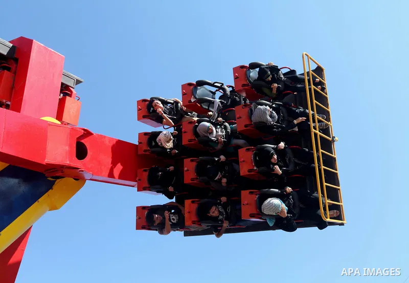 Palestinians enjoy a ride in an amusement park on the third day of Eid al-Fitr, marking the end of Islam's fasting holy month of Ramadan, in Gaza City on August 21, 2012. Photo by Majdi Fathi