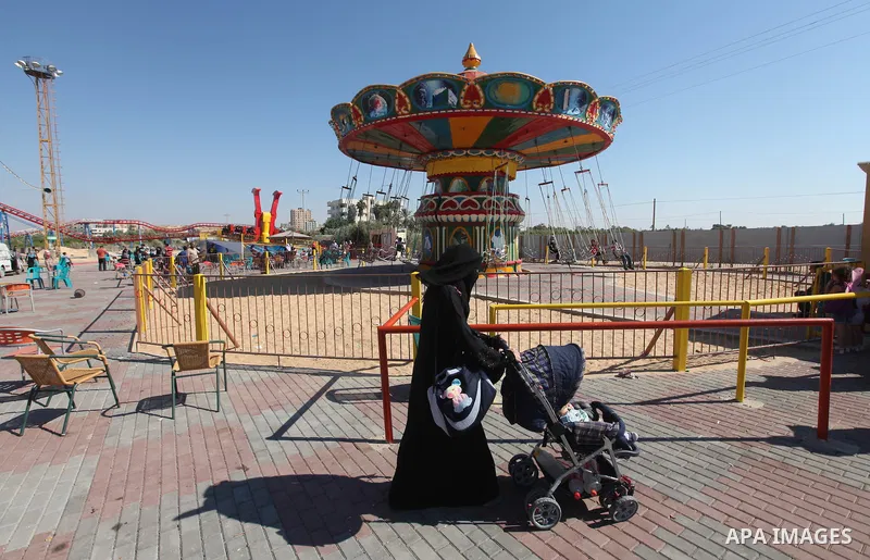 Palestinians enjoy a ride in an amusement park on the third day of Eid al-Fitr, marking the end of Islam's fasting holy month of Ramadan, in Gaza City on August 21, 2012. Photo by Majdi Fathi