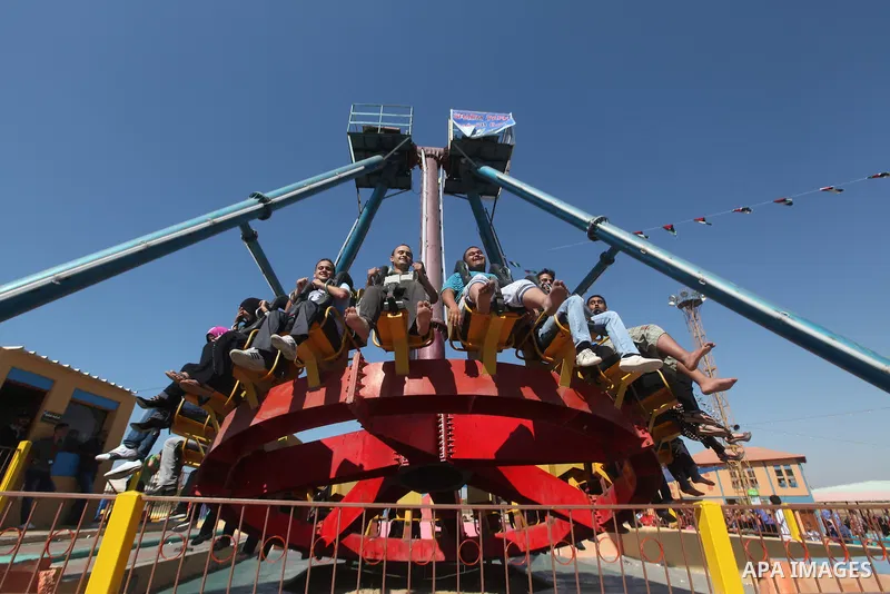 Palestinians enjoy a ride in an amusement park on the third day of Eid al-Fitr, marking the end of Islam's fasting holy month of Ramadan, in Gaza City on August 21, 2012. Photo by Majdi Fathi