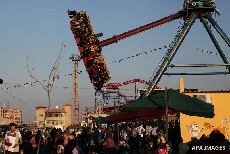 Palestinians enjoy a ride in an amusement park on the third day of Eid al-Fitr, marking the end of Islam's fasting holy month of Ramadan, in Gaza City on August 21, 2012. Photo by Ashraf Amra