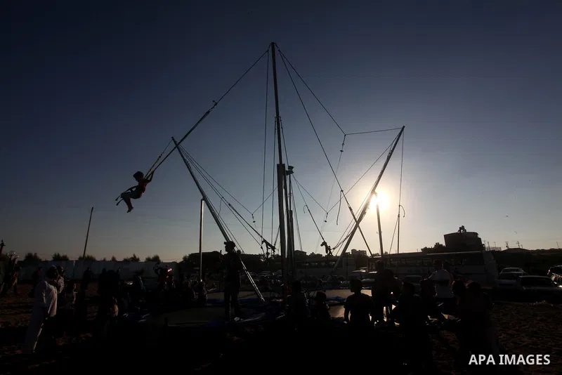 Palestinians enjoy a ride in an amusement park on the third day of Eid al-Fitr, marking the end of Islam's fasting holy month of Ramadan, in Gaza City on August 21, 2012. Photo by Ashraf Amra