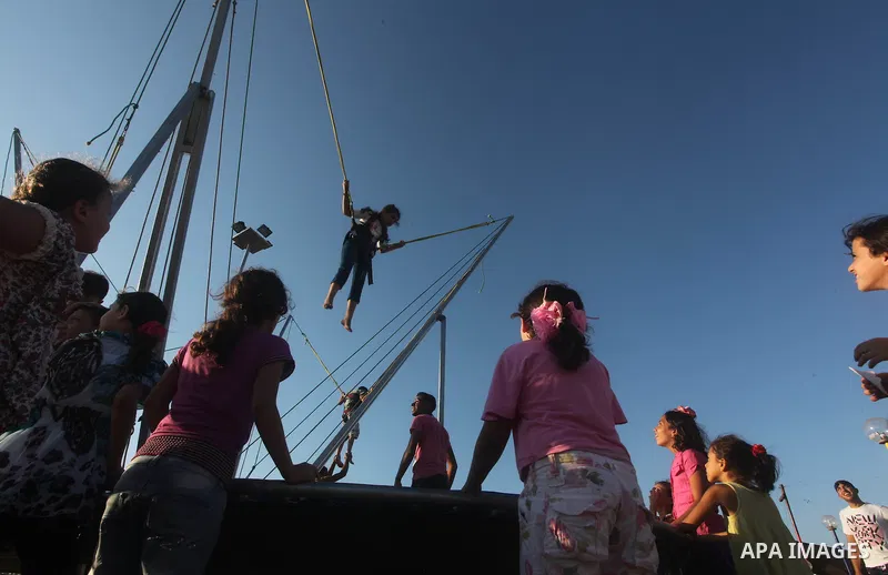 Palestinians enjoy a ride in an amusement park on the third day of Eid al-Fitr, marking the end of Islam's fasting holy month of Ramadan, in Gaza City on August 21, 2012. Photo by Ashraf Amra