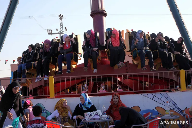 Palestinians enjoy a ride in an amusement park on the third day of Eid al-Fitr, marking the end of Islam's fasting holy month of Ramadan, in Gaza City on August 21, 2012. Photo by Ashraf Amra