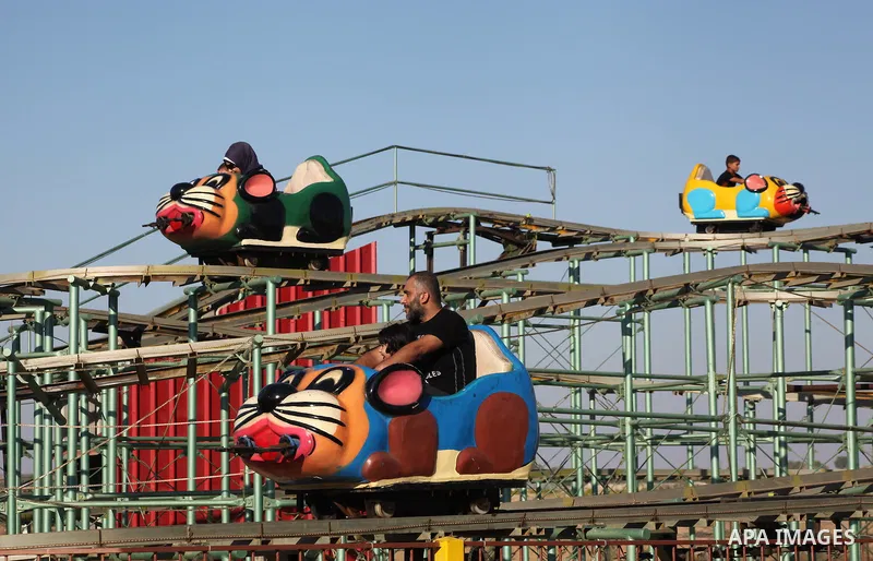 Palestinians enjoy a ride in an amusement park on the third day of Eid al-Fitr, marking the end of Islam's fasting holy month of Ramadan, in Gaza City on August 21, 2012. Photo by Ashraf Amra