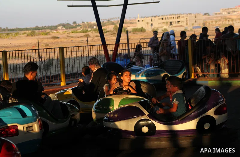 Palestinians enjoy a ride in an amusement park on the third day of Eid al-Fitr, marking the end of Islam's fasting holy month of Ramadan, in Gaza City on August 21, 2012. Photo by Ashraf Amra