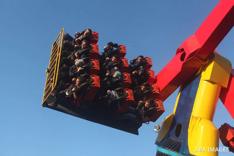 Palestinians enjoy a ride in an amusement park on the third day of Eid al-Fitr, marking the end of Islam's fasting holy month of Ramadan, in Gaza City on August 21, 2012. Photo by Ashraf Amra