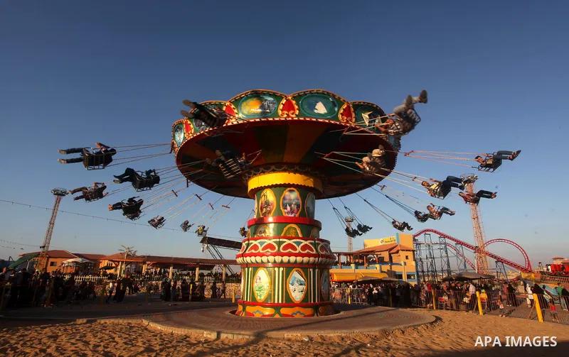 Palestinians enjoy a ride in an amusement park on the third day of Eid al-Fitr, marking the end of Islam's fasting holy month of Ramadan, in Gaza City on August 21, 2012. Photo by Ashraf Amra