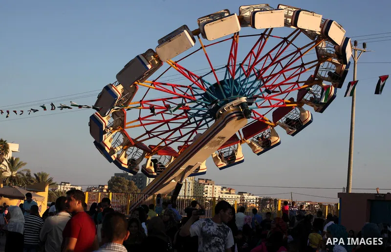 Palestinians enjoy a ride in an amusement park on the third day of Eid al-Fitr, marking the end of Islam's fasting holy month of Ramadan, in Gaza City on August 21, 2012. Photo by Ashraf Amra