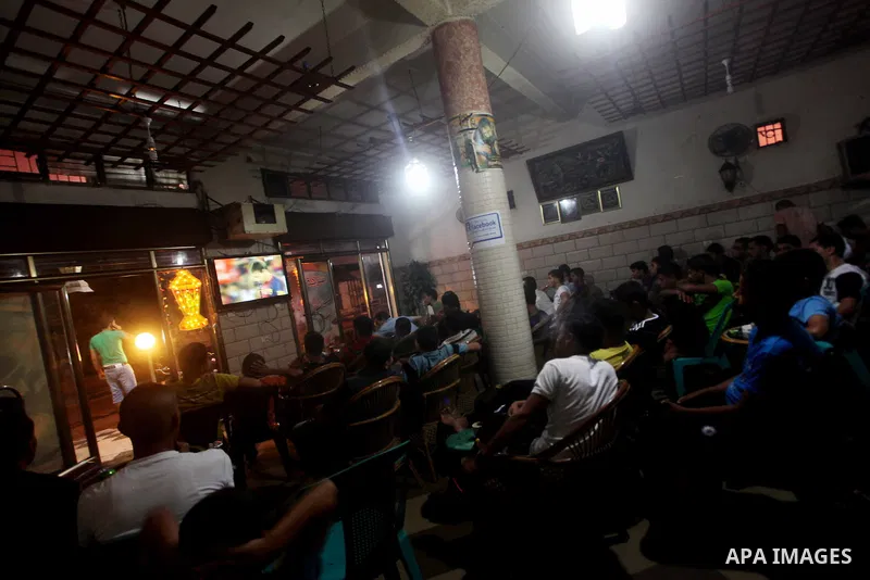 Palestinian youths watch a soccer match for FC Barcelona team against Real Madrid team during a Spanish Supercup at cafe in Deir al-Balah central Gaza Strip, on Aug 23, 2012. Photo by Ashraf Amra
