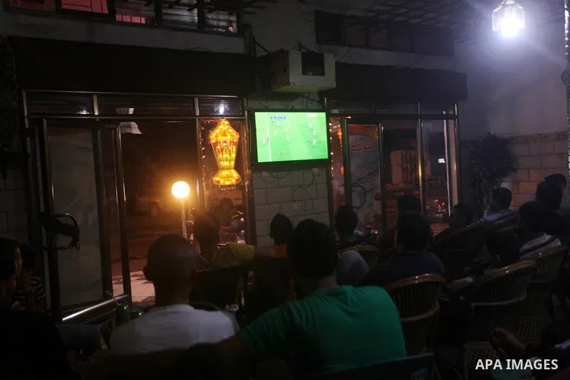 Palestinian youths watch a soccer match for FC Barcelona team against Real Madrid team during a Spanish Supercup at cafe in Deir al-Balah central Gaza Strip, on Aug 23, 2012. Photo by Ashraf Amra