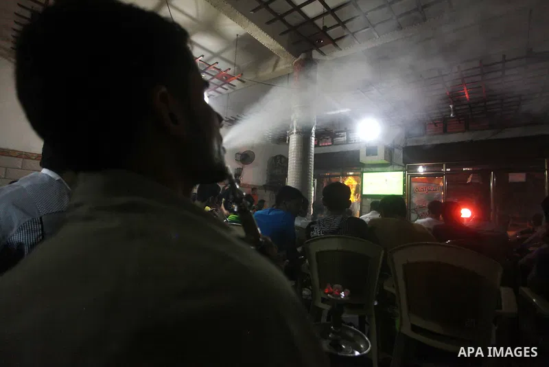 Palestinian youths watch a soccer match for FC Barcelona team against Real Madrid team during a Spanish Supercup at cafe in Deir al-Balah central Gaza Strip, on Aug 23, 2012. Photo by Ashraf Amra