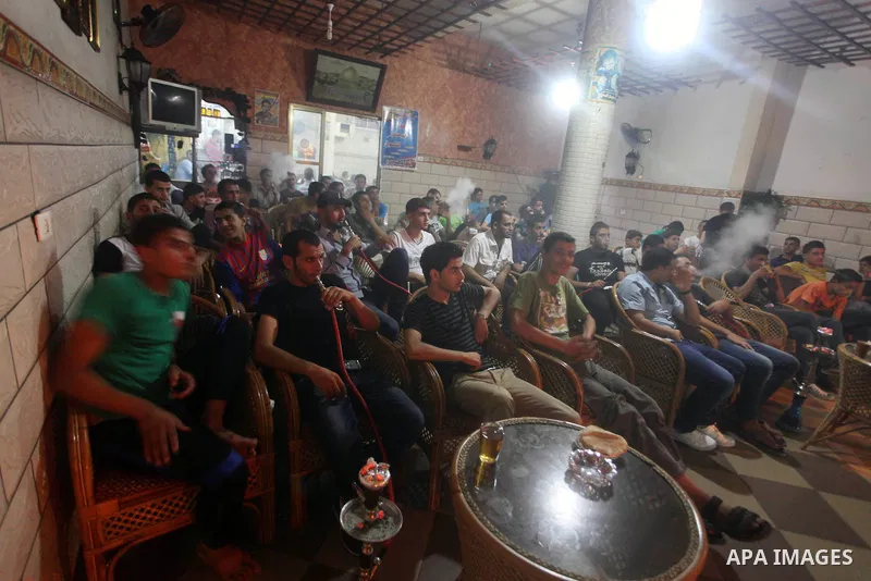 Palestinian youths watch a soccer match for FC Barcelona team against Real Madrid team during a Spanish Supercup at cafe in Deir al-Balah central Gaza Strip, on Aug 23, 2012. Photo by Ashraf Amra