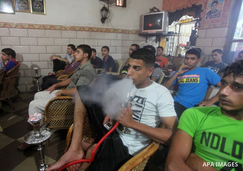 Palestinian youths watch a soccer match for FC Barcelona team against Real Madrid team during a Spanish Supercup at cafe in Deir al-Balah central Gaza Strip, on Aug 23, 2012. Photo by Ashraf Amra