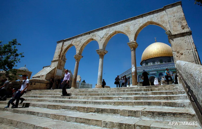 Palestinians walk in front of the Dome of Rock mosque during Friday prayers, in the al-Aqsa Mosque compound, in Jerusalem's old city on Aug 24, 2012. Photo by Mahfouz Abu Turk