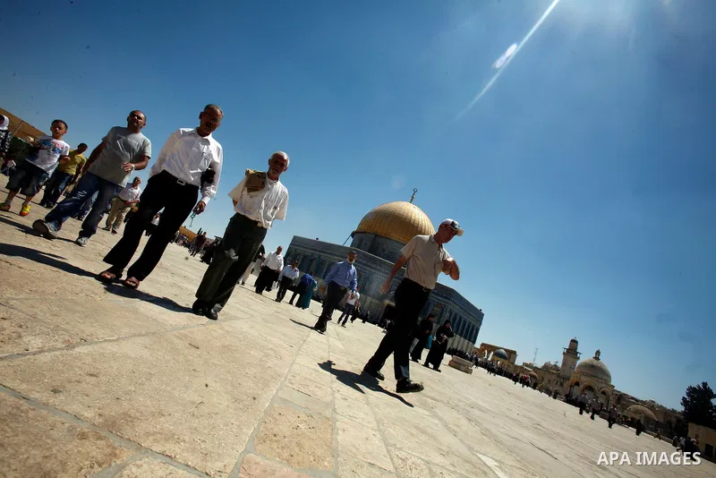 Palestinians walk in front of the Dome of Rock mosque during Friday prayers, in the al-Aqsa Mosque compound, in Jerusalem's old city on Aug 24, 2012. Photo by Mahfouz Abu Turk