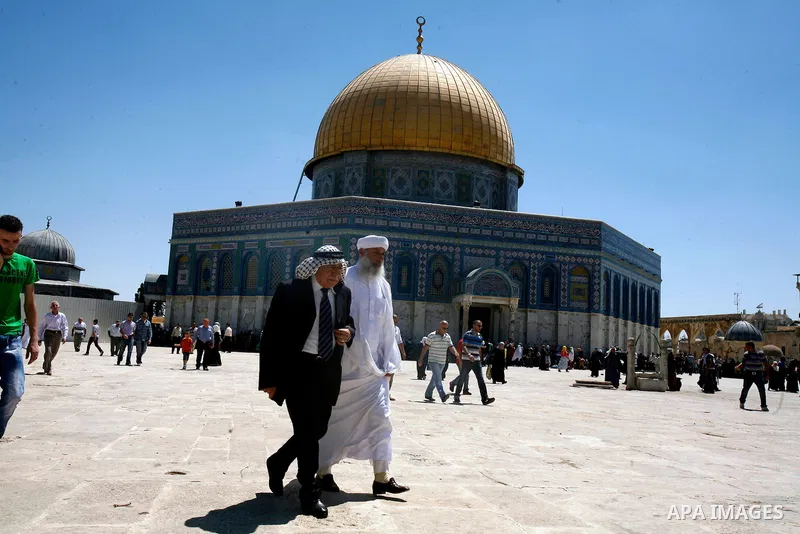Palestinians walk in front of the Dome of Rock mosque during Friday prayers, in the al-Aqsa Mosque compound, in Jerusalem's old city on Aug 24, 2012. Photo by Mahfouz Abu Turk