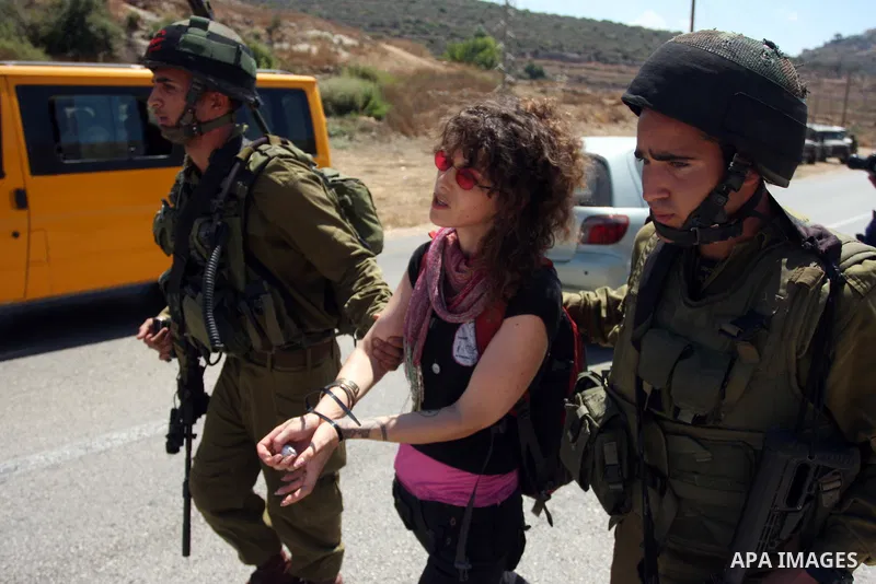Israeli soldiers detain a Palestinian woman during a demonstration in the West Bank village of Nabi Saleh in protest against the confiscation of Palestinian land to expand the nearby Jewish settlement of Halamish on Augu...