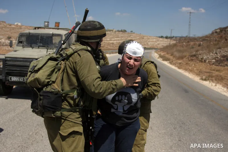 Israeli soldiers detain a Palestinian woman during a demonstration in the West Bank village of Nabi Saleh in protest against the confiscation of Palestinian land to expand the nearby Jewish settlement of Halamish on Augu...