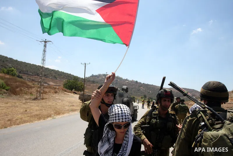Israeli soldiers stops Palestinian woman during a demonstration in the West Bank village of Nabi Saleh in protest against the confiscation of Palestinian land to expand the nearby Jewish settlement of Halamish on August...