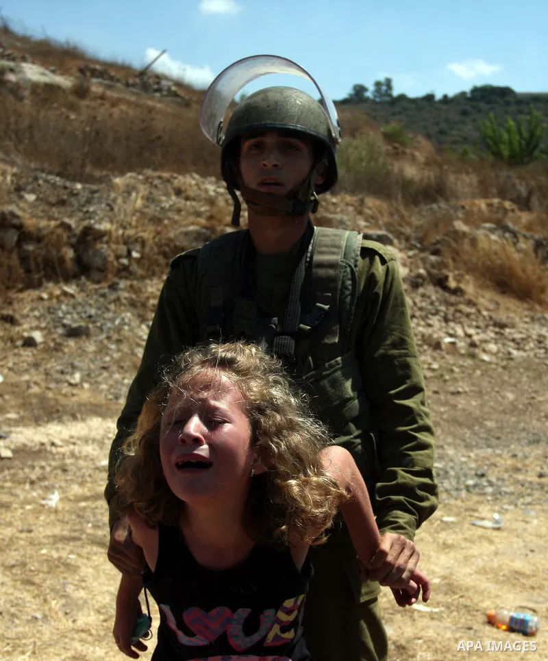 An Israeli soldier stops a Palestinian girl, as others detain her mother during a demonstration in the West Bank village of Nabi Saleh in protest against the confiscation of Palestinian land to expand the nearby Jewish s...