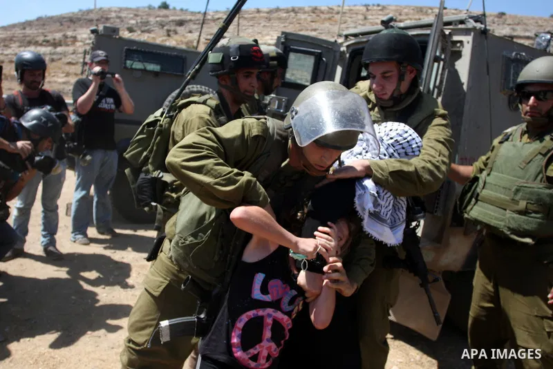 A Palestinian girl holds on to her mother as Israeli soldiers detain her during a demonstration in the West Bank village of Nabi Saleh in protest against the confiscation of Palestinian land to expand the nearby Jewish s...