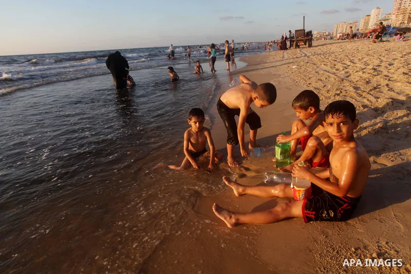 Palestinian children enjoy swimming in the sea at Gaza beach during Friday holiday in Gaza city, Aug 24, 2012. Gazans escape to the beach and out from their homes during heat wave and power outages. Photo by Ashraf Amra