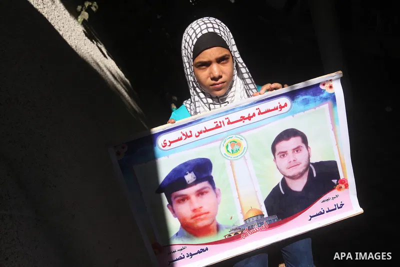 Palestinians hold pictures of their relatives prisoners in Israeli jails as they gather in an activity calling for their liberty at the Red Cross headquarters in Gaza City on Aug. 27, 2012. Photo by Majdi Fathi