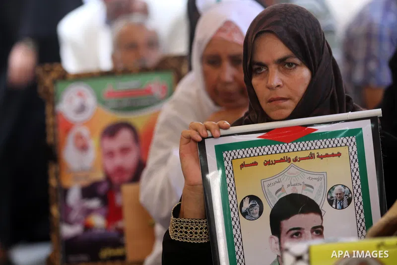 Palestinians hold pictures of their relatives prisoners in Israeli jails as they gather in an activity calling for their liberty at the Red Cross headquarters in Gaza City on Aug. 27, 2012. Photo by Majdi Fathi