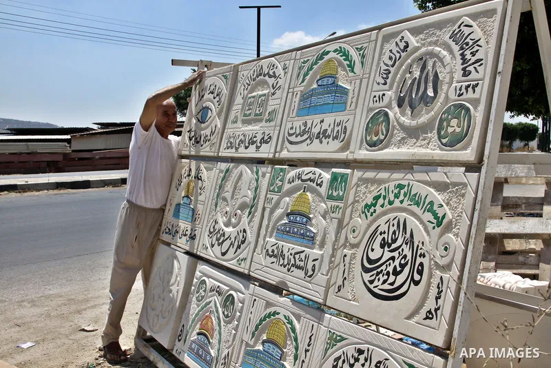 A Palestinian man displays the stones carved out of rock and painted it the Dome of the Rock in order to sell it, in the West Bank City of Nablus, on Aug. 27, 2012. Photo by Nedal Eshtayah