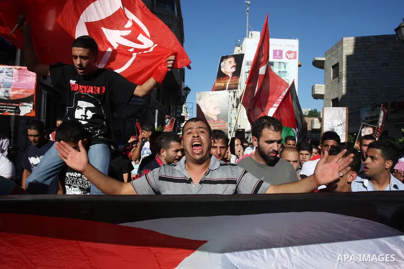 Hundreds of supporters of the Palestinian Front for the Liberation of Palestine (PFLP) shout slogans during a rally mark the 11th anniversary of the assassination of PFLP leader Abu Ali Mustafa, in the West Bank city of...