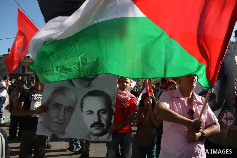 Hundreds of supporters of the Palestinian Front for the Liberation of Palestine (PFLP) wave red flags and pictures of the PFLP leader Abu Ali Mustafa during a rally mark the 11th anniversary of assassinate him, in the We...