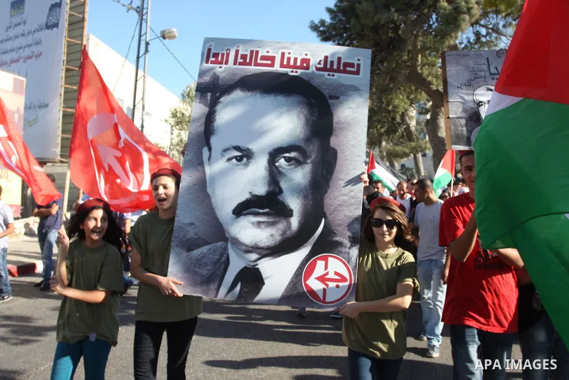 Hundreds of supporters of the Palestinian Front for the Liberation of Palestine (PFLP) wave red flags and pictures of the PFLP leader Abu Ali Mustafa during a rally mark the 11th anniversary of assassinate him, in the We...