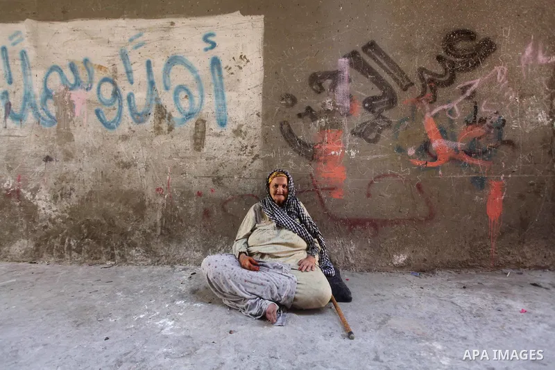An elderly Palestinian woman sits on the ground outside her home at Al-Shati refugee camp in Gaza City on August 28, 2012. Life in the poor and crowded Gaza Strip is going to get harsher still unless action is taken now,...