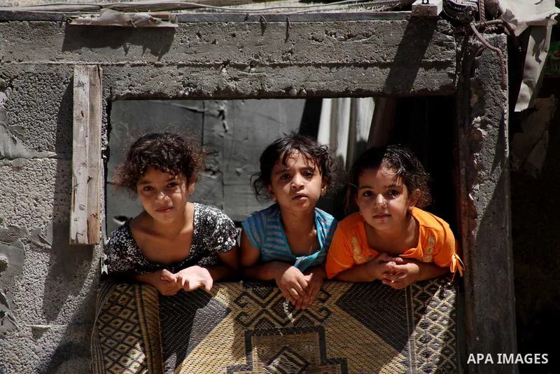 Palestinian children See from the window of their home at Al-Shati refugee camp in Gaza City on August 28, 2012. Life in the poor and crowded Gaza Strip is going to get harsher still unless action is taken now, according...