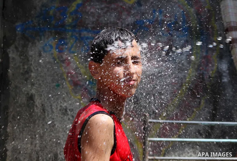 A Palestinian boy enjoys himself with water during hot weather at Al-Shati refugee camp in Gaza City on August 28, 2012. Life in the poor and crowded Gaza Strip is going to get harsher still unless action is taken now, a...