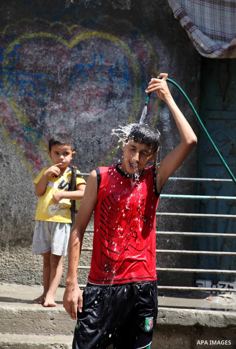 A Palestinian boy enjoys himself with water during hot weather at Al-Shati refugee camp in Gaza City on August 28, 2012. Life in the poor and crowded Gaza Strip is going to get harsher still unless action is taken now, a...