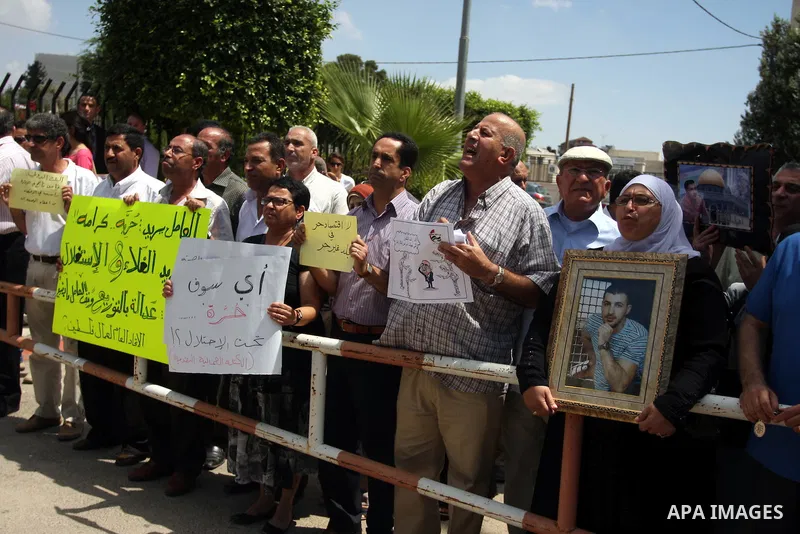 Palestinian protesters hold signs during a demonstration against the the high expenses of Palestinian Prime Minister Salam Fayad, outside the office of the presidency of the government, in the West Bank city of Ramallah,...