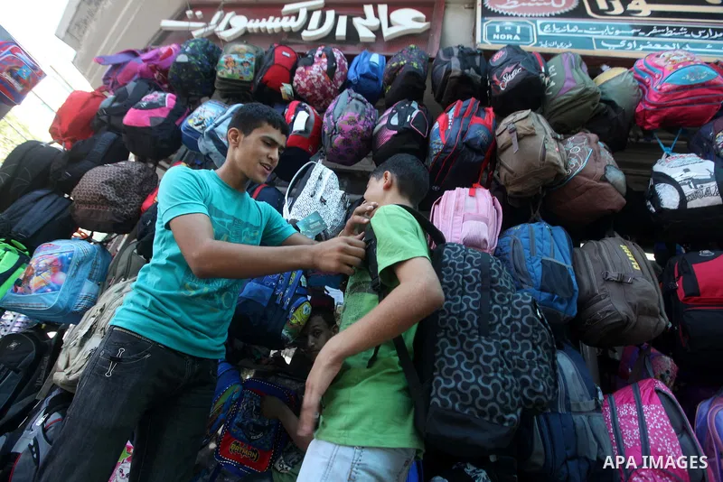 A Palestinian boy buys a new school bag at a market in Gaza city on Aug 28, 2012. Next Sunday the First day for the new school year according to Palestinian Ministry of Education in the Gaza strip and the West Bank. Phot...