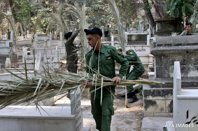 Palestinian security members volunteer clean the cemeteries during the campaign "Cleanliness " in the West Bank city OF Nablus, on Aug. 29, 2012. Photo by Nedal Eshtayah