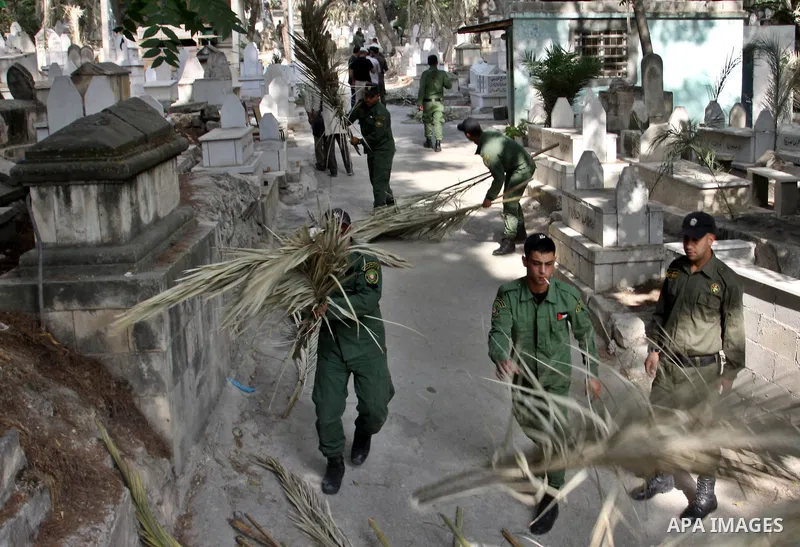 Palestinian security members volunteer clean the cemeteries during the campaign "Cleanliness " in the West Bank city OF Nablus, on Aug. 29, 2012. Photo by Nedal Eshtayah