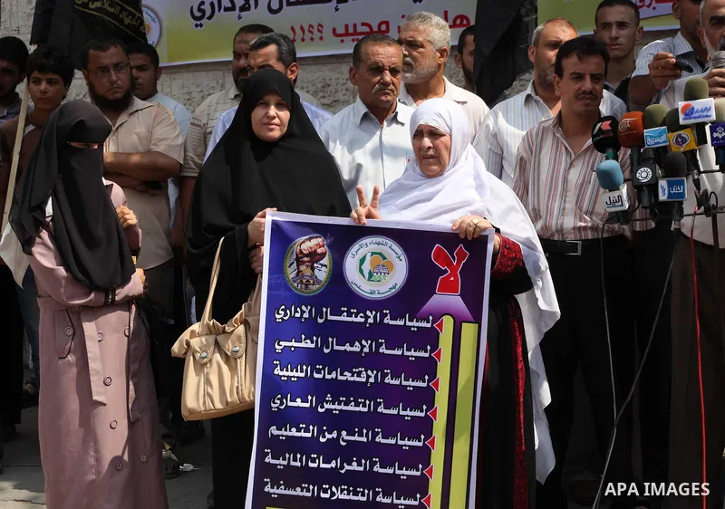 Palestinians hold up signs during a protest against administrative detention of Palestinian prisoners In Israeli jails, in front of the Red Cross headquarters in Gaza City on Aug. 29, 2012. Photo by Ashraf Amra