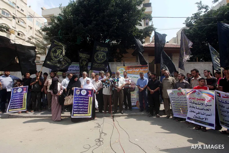 Palestinians hold up signs during a protest against administrative detention of Palestinian prisoners In Israeli jails, in front of the Red Cross headquarters in Gaza City on Aug. 29, 2012. Photo by Ashraf Amra
