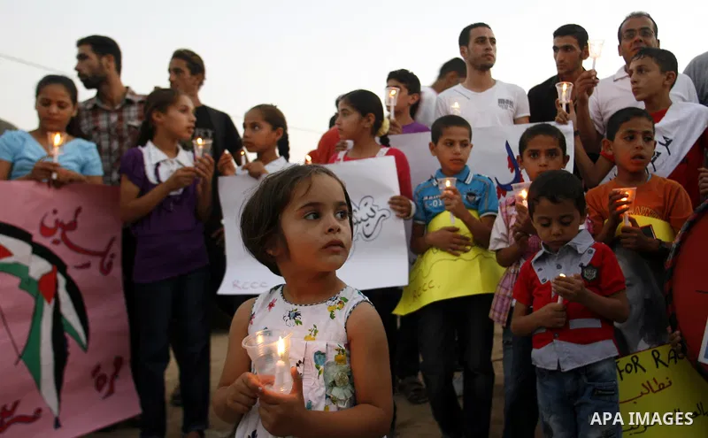 Palestinian children hold candles during a protest in Rafah in the southern Gaza Strip, against an Israeli court's ruling, August 29, 2012. The Israeli court on Tuesday cleared Israel's military of any blame for the deat...