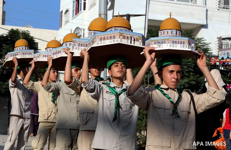 Palestinian boy scouts carry statues of the Dome of the Rock mosque during a festival entitled "Jerusalem in our eyes" organized by Hamas movement, marking the 43rd anniversary of burning down al-Aqsa mosque in Gaza city...