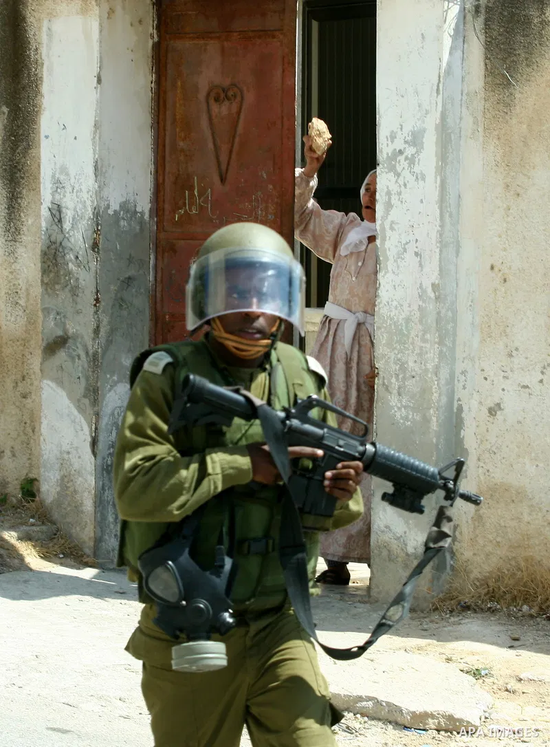Palestinian woman attacks Israeli soldiers during clashes against the expropriation of Palestinian land by Israel in the village of Kafr Qaddum, near the West Bank city of Nablus on August 31, 2012. Photo by Nedal Eshtay...