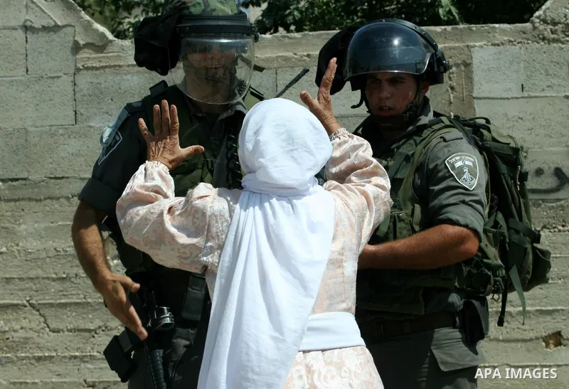 Palestinian woman attacks Israeli soldiers during clashes against the expropriation of Palestinian land by Israel in the village of Kafr Qaddum, near the West Bank city of Nablus on August 31, 2012. Photo by Nedal Eshtay...